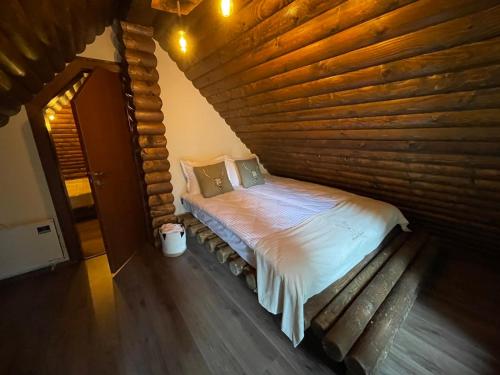 a bed in a room with a wooden wall at CHALET ELEVEN in Dospat