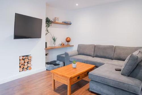 a living room with a couch and a coffee table at Tu Casa Brighton , A Beautiful & Peaceful 4 bedroom House with garden, BBq area , EV & Parking in Brighton & Hove