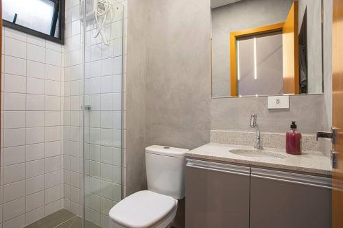uma casa de banho com um WC, um lavatório e um chuveiro em Loft 102 em Curitiba
