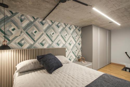 um quarto com uma grande cama branca com uma parede de acento em Loft 102 em Curitiba