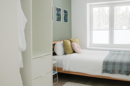 a bedroom with a bed and a window at Modern and cosy apartment in Lahemaa national park in Kolga