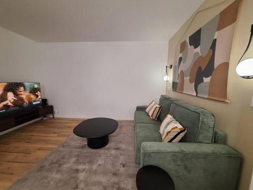 un salon avec un canapé, une table et une télévision dans l'établissement Le Traditionnel - En bordure de Paris - 322B, à Rueil-Malmaison