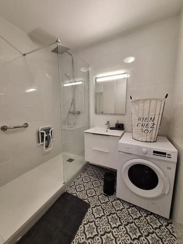 une salle de bain avec une machine à laver et un lavabo dans l'établissement Le Traditionnel - En bordure de Paris - 322B, à Rueil-Malmaison