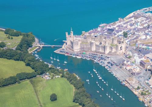 an aerial view of a castle and a river with boats at 180 River View Cabin in Caeathro