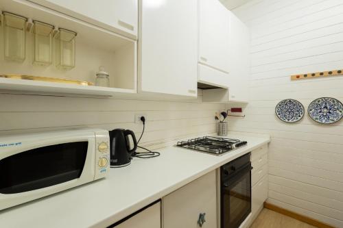 a kitchen with a microwave and a stove at Tourist House Bologna Pratellino - Self Check-in in Bologna