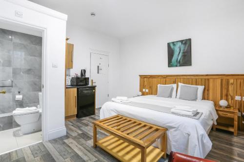 a bedroom with a large bed and a bathroom at BeiRoom Hyde Park Apartments in London