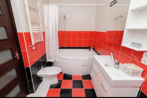 baño rojo y blanco con aseo y lavamanos en Stylish apartment 001, en Chişinău