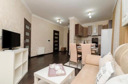sala de estar con sofá, mesa y cocina en Stylish apartment 001, en Chişinău