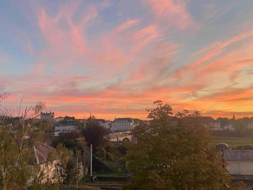 - une vue sur une ville avec un ciel nuageux au coucher du soleil dans l'établissement L’ escale, à Saumur