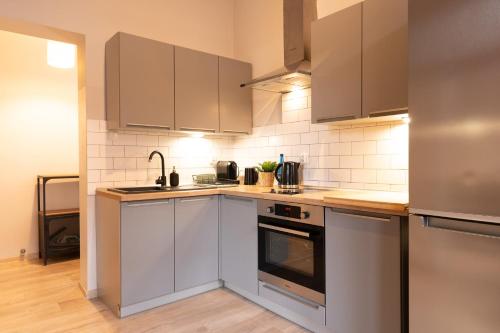 a kitchen with stainless steel appliances and brown cabinets at Central LOFT in Nowe Miasto Lubawskie