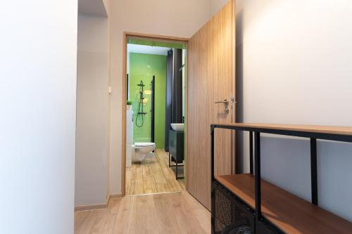 a bathroom with a toilet and a green wall at Central LOFT in Nowe Miasto Lubawskie