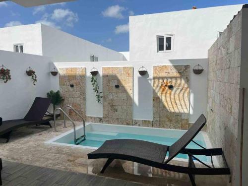 uma piscina com duas cadeiras e uma piscina em Espectacular alojamiento em Punta Cana
