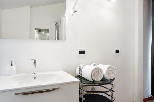 a white bathroom with a sink and a mirror at Casa Gallinotto in Alba