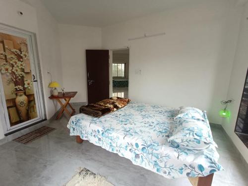 a bedroom with a bed with a blue and white comforter at Traveller's Nest in Siliguri
