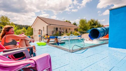 a group of people playing in a swimming pool at Flower Camping La Sténiole in Granges-sur-Vologne