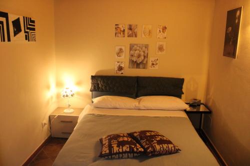 1 dormitorio con 1 cama con cabecero y cuadros en la pared en La Colombaia Di Ortigia, en Siracusa