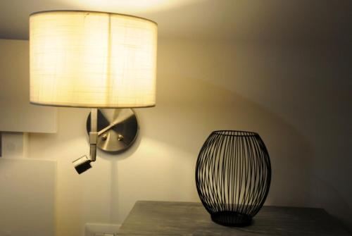 una lámpara sentada en la parte superior de una mesa junto a una sidra de mesa en Casa vacanze Santa Marta, en Barletta