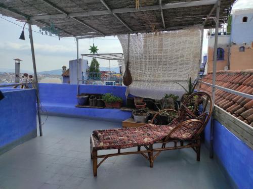 a chair sitting on top of a building with a blue wall at Vallparadis Pension Familiar" FIRDAUS" in Chefchaouene