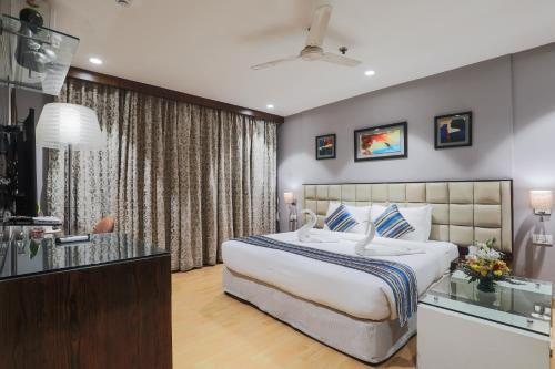 a bedroom with a large bed and a kitchen at Hotel Bluestone Nehru Place by The Cosy Hotels in New Delhi
