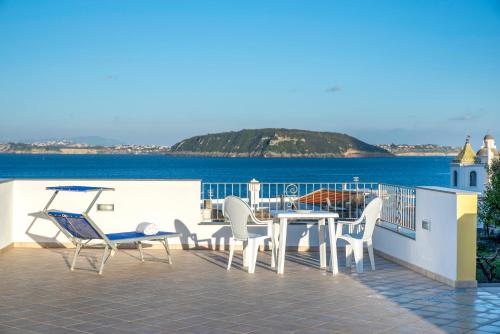 a balcony with a table and chairs and the ocean at B&B La Vigna - Ischia Ponte in Ischia