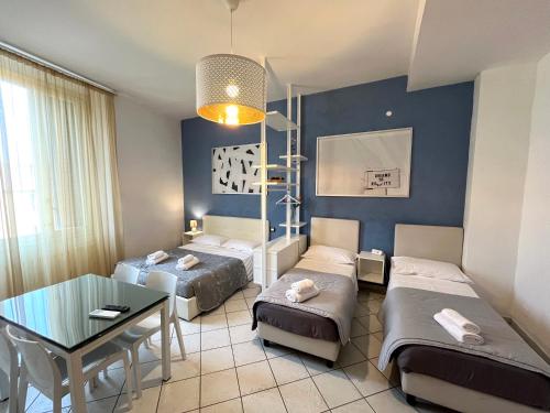 ボローニャにあるLa Suite Rooms & Apartmentsのベッド2台とテーブルが備わる客室です。