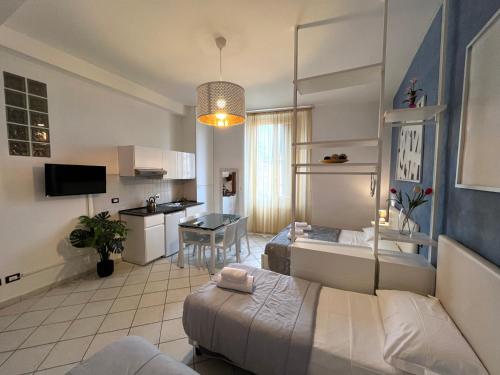 sala de estar con 2 camas y cocina en La Suite Rooms & Apartments, en Bolonia