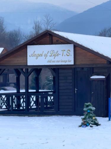 a building with a sign on it in the snow at Moonglade Allure Houses in Polyana