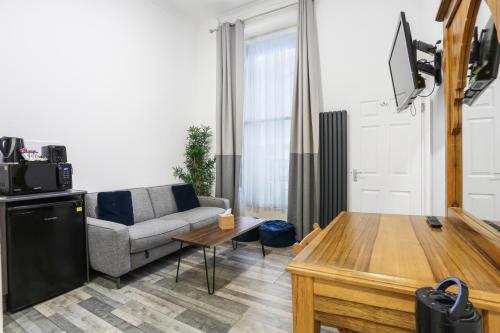 a living room with a couch and a table at BeiRoom Hyde Park Apartments in London