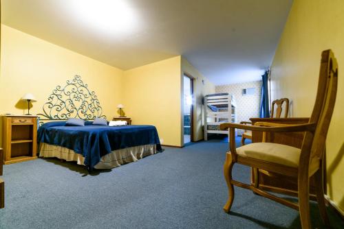 um quarto com uma cama azul e uma cadeira em Hotel de France Rio Ceballos em Río Ceballos