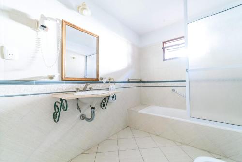 La salle de bains est pourvue d'un lavabo, d'une baignoire et d'un miroir. dans l'établissement Hotel de France Rio Ceballos, à Río Ceballos
