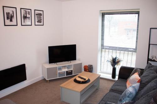 a living room with a couch and a tv at RestWorkPlayShortStays apartment, free parking and wifi, perfect for contractors, near to i54 park and city centre in Wolverhampton