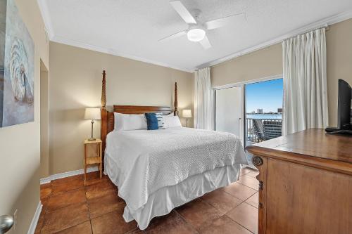 a bedroom with a bed and a tv and a window at South Harbour Unit 2D in Pensacola Beach