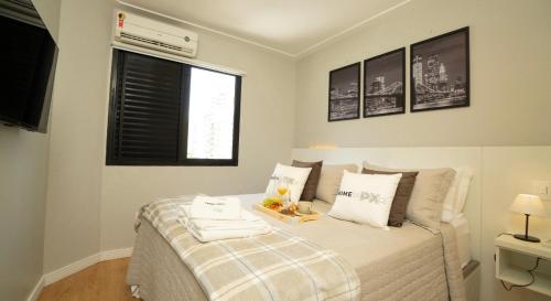 a white bedroom with a bed with a window at Flat Jardim Paulista II - SP - Próximo da AV Paulista e ao lado do Shopping Pamplona in Sao Paulo