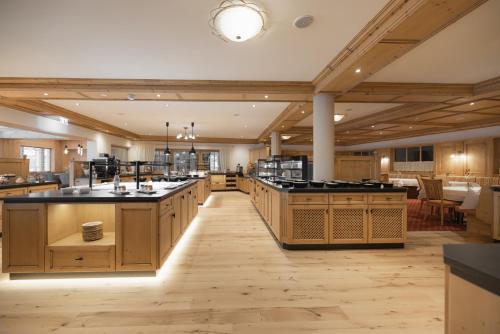 a large kitchen with wooden cabinets and black counter tops at KERSCHDORFER - wohlfühlhotel garni - adults only in Kaltenbach