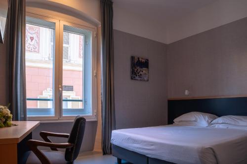 a bedroom with a bed and a desk and a window at Hotel Italia e Lido Rapallo in Rapallo