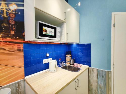 eine Küche mit einer Spüle und einer Mikrowelle in der Unterkunft King Apartment in Budapest