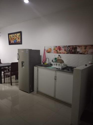 a kitchen with a stove and a refrigerator at Apartaestudio G&J in Neiva