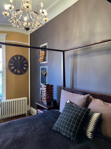 a bedroom with a bed and a clock on the wall at Soul Food 'Mont Morris' in New York