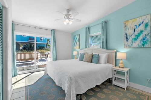 een slaapkamer met een bed en een balkon bij Aquaverde Beach House in Pensacola Beach