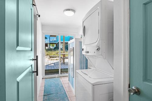 een wasruimte met een wasmachine en droger naast een deur bij Aquaverde Beach House in Pensacola Beach