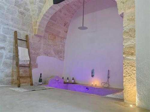 a room with a purple altar in a stone wall at Dimore i Messapi Suites in Ceglie Messapica