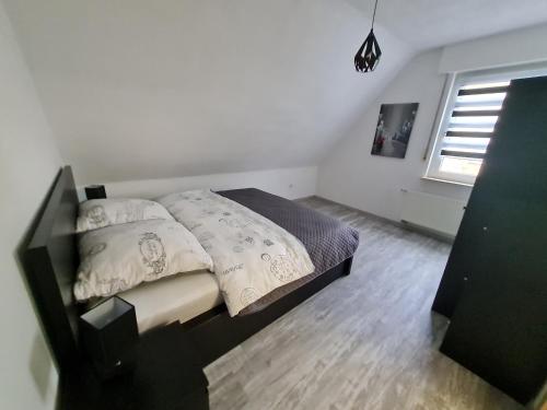1 dormitorio con cama con almohadas y ventana en Im Herzen von Paderborn, en Paderborn