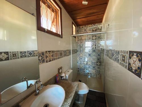 a bathroom with a sink and a shower and a toilet at Macondo Chalés in Lavras Novas