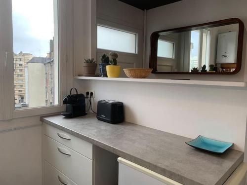 une cuisine avec un comptoir avec un miroir et une fenêtre dans l'établissement Le Saint HeL, Magnifique T2 en face du TNB, à Rennes