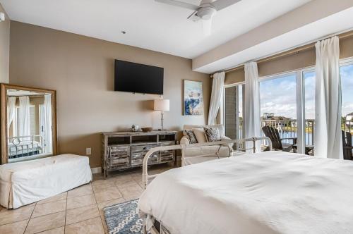 ein Schlafzimmer mit einem großen Bett und einem Fernseher in der Unterkunft Beach N' Bay in Pensacola Beach