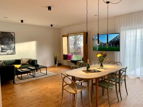sala de estar con mesa, sillas y sofá en Luxus-Ferienhaus mit Saunen und großem Garten en Göhren-Lebbin
