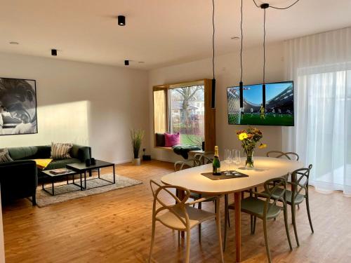 a living room with a table and chairs and a couch at Luxus-Ferienhaus mit Saunen und großem Garten in Göhren-Lebbin