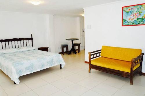 1 dormitorio con cama y banco amarillo en Loft Santo Antônio Além do Carmo, en Salvador