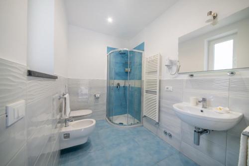 uma casa de banho branca com um lavatório e um chuveiro em B&B La Vigna - Ischia Ponte em Ischia