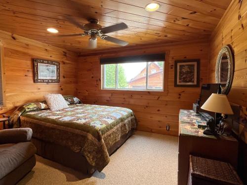 a bedroom with a bed and a ceiling fan at Black Moose Lodge 